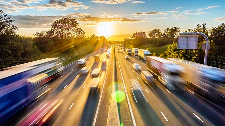 heavy traffic moving at speed on UK motorway in England at sunset.